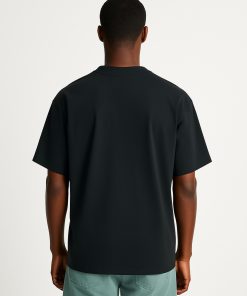 Hombre con camiseta oversized negra sin estampado, vista trasera.