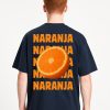 Vista trasera de camiseta azul marino oversized con texto “NARANJA” en naranja y media naranja impresa; diseño gráfico llamativo con estética fresca y juvenil.