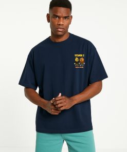 Camiseta oversized azul marino con mini ilustración “Vitamin C” en el pecho; look fresco y original con diseño gráfico de frutas humanizadas.